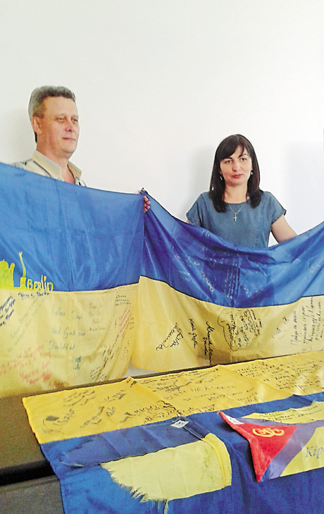 Активісти громадського руху «Очищення» Сергій П’ятниця й Ірина Сафронова демонструють зібрані на блокпостах бойові прапори. Фото автора